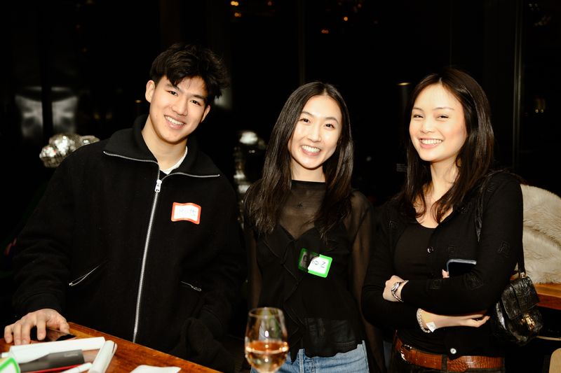 Three guests standing at a high table